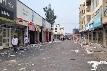 A scattering of people walk through a commercial district in Goma.